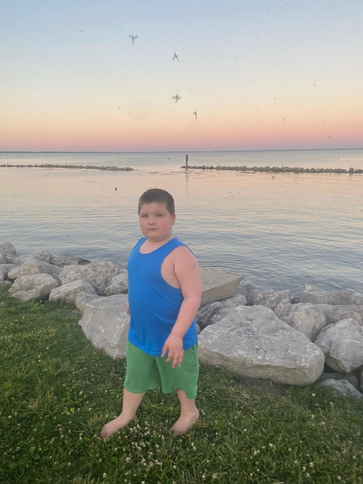 Jaxson standing by the water at sunset